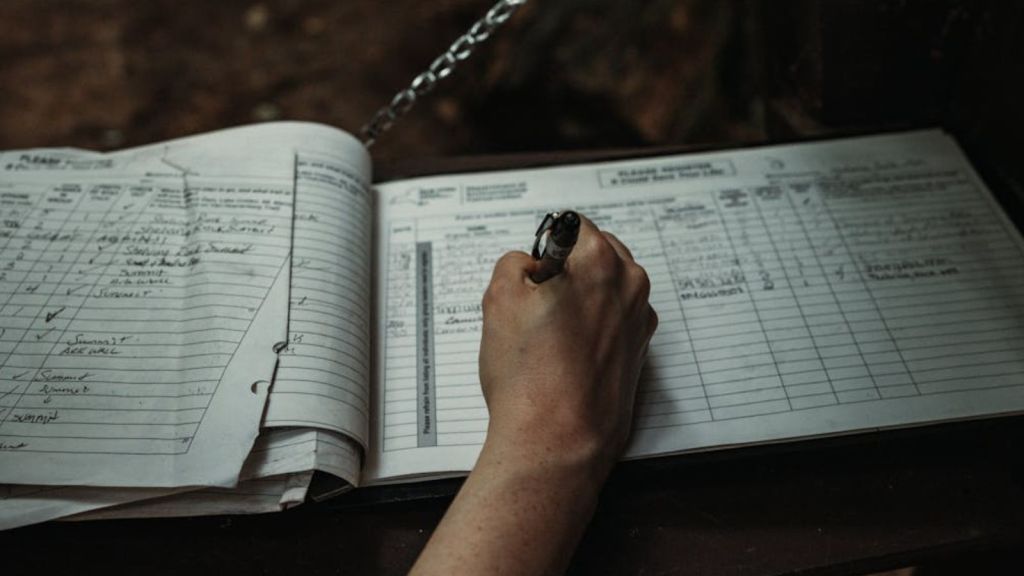 Person singing their name on a logbook
