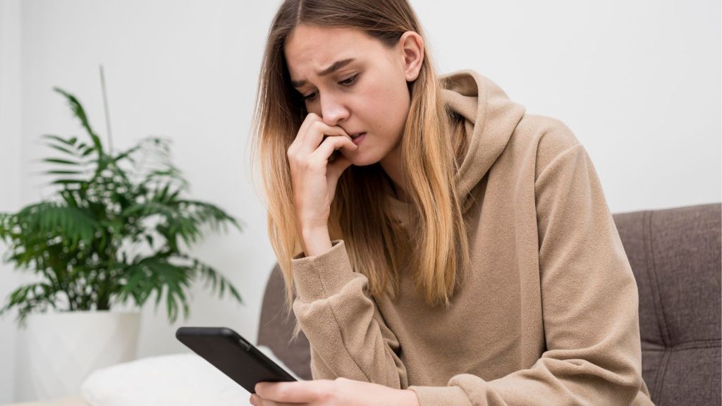 Woman with worried face looking at her phone