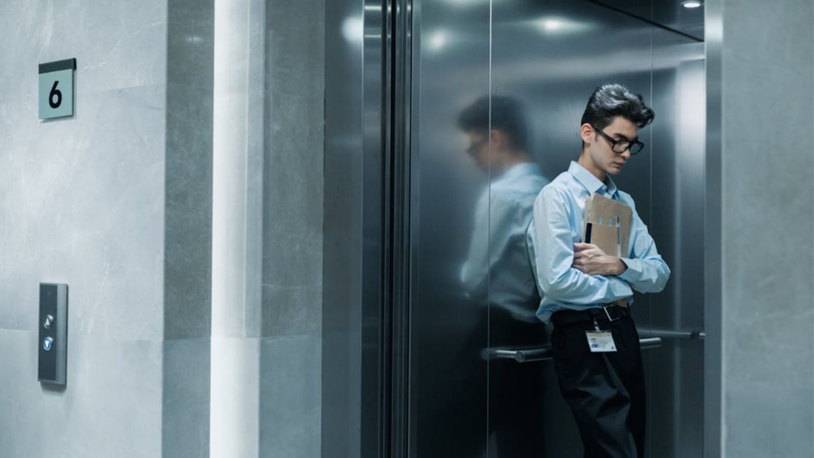 Man in business attire inside an open elevator