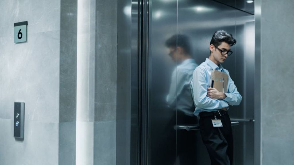 Man in business attire inside an open elevator