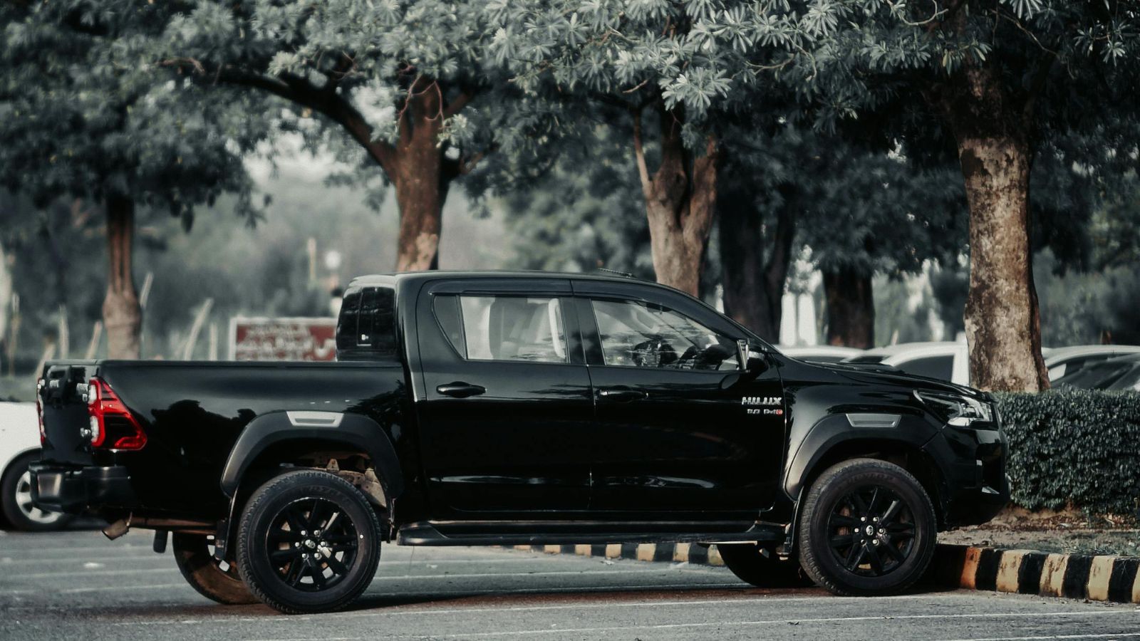 A black truck parked on a shaded parking lot
