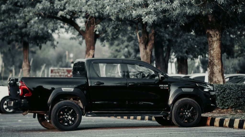 A black truck parked on a shaded parking lot