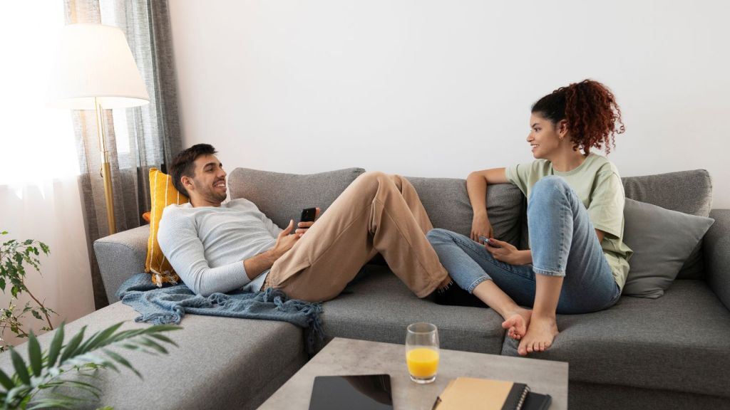 Man and woman happily chatting on the couch