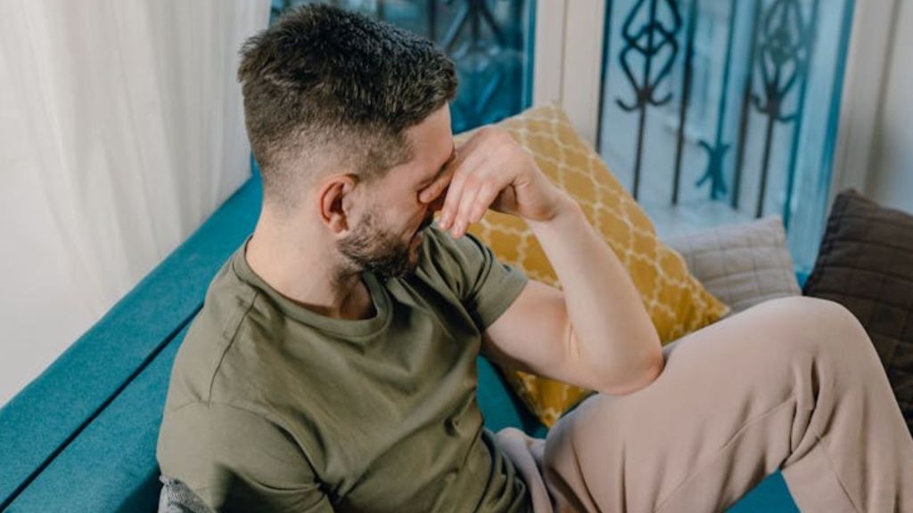 Man crying while sitting on the couch