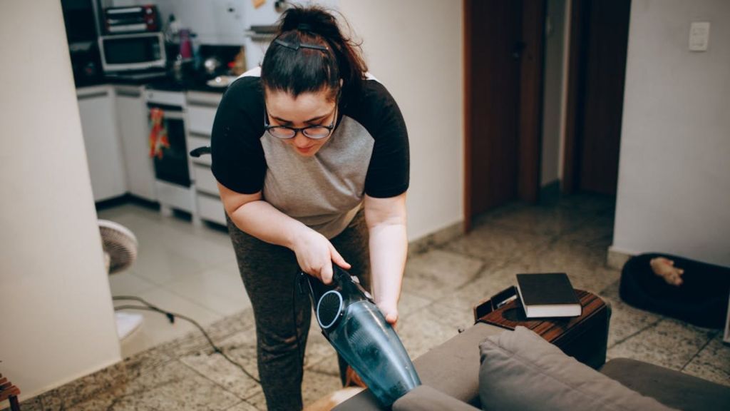 Woman vacuuming the sofa
