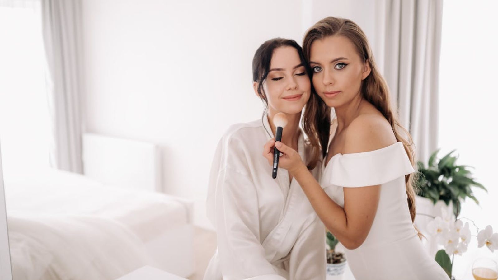 Bride Faces Backlash Over Child Free Wedding After Making Exception for Teen Niece Bride getting ready for her wedding with a woman holding a makeup brush
