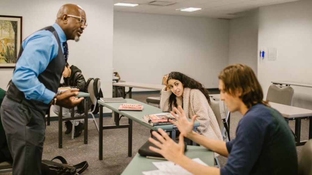 Professor talking to college students in the classroom