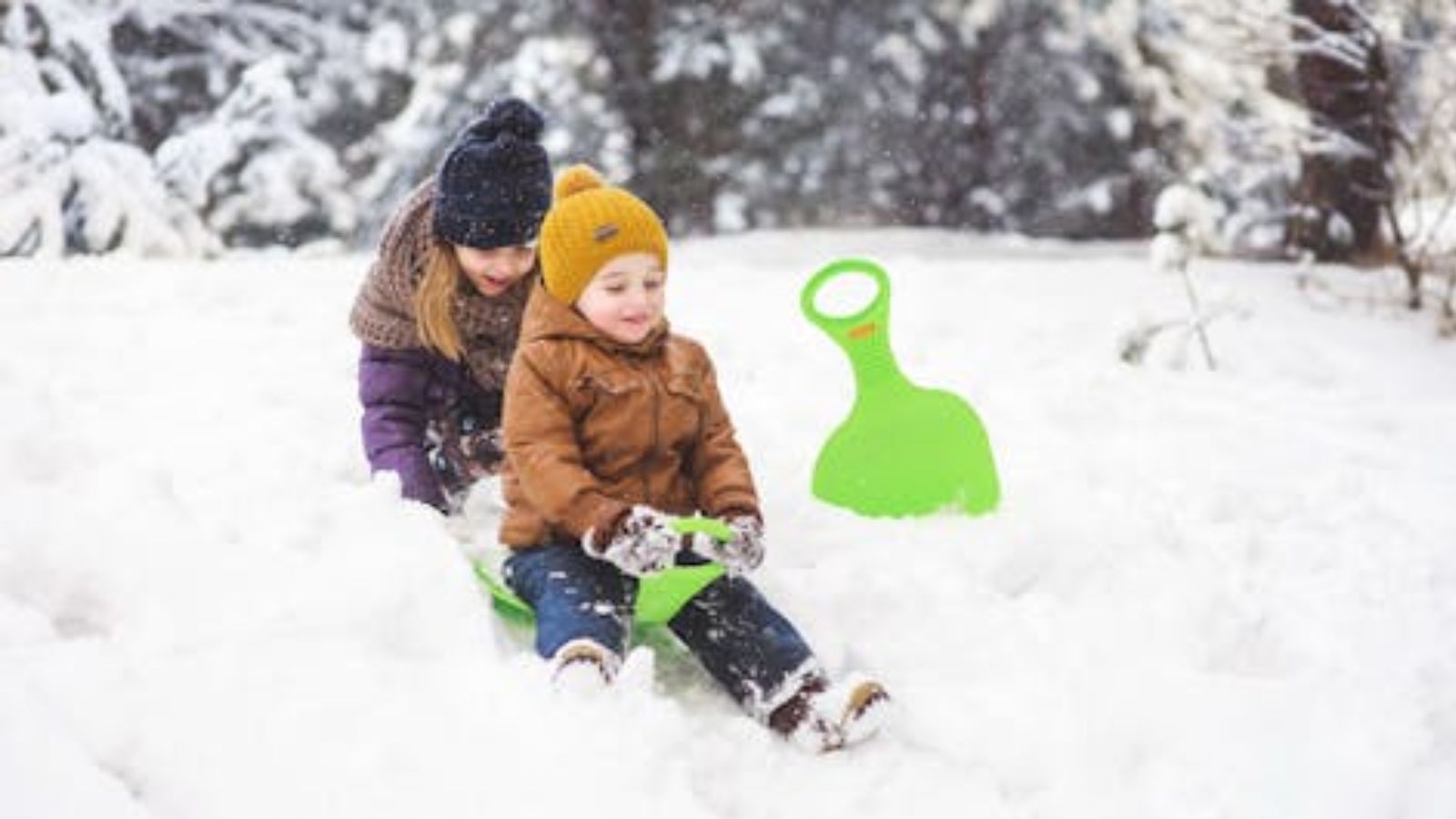 Girl and boy playing on the snow in winter