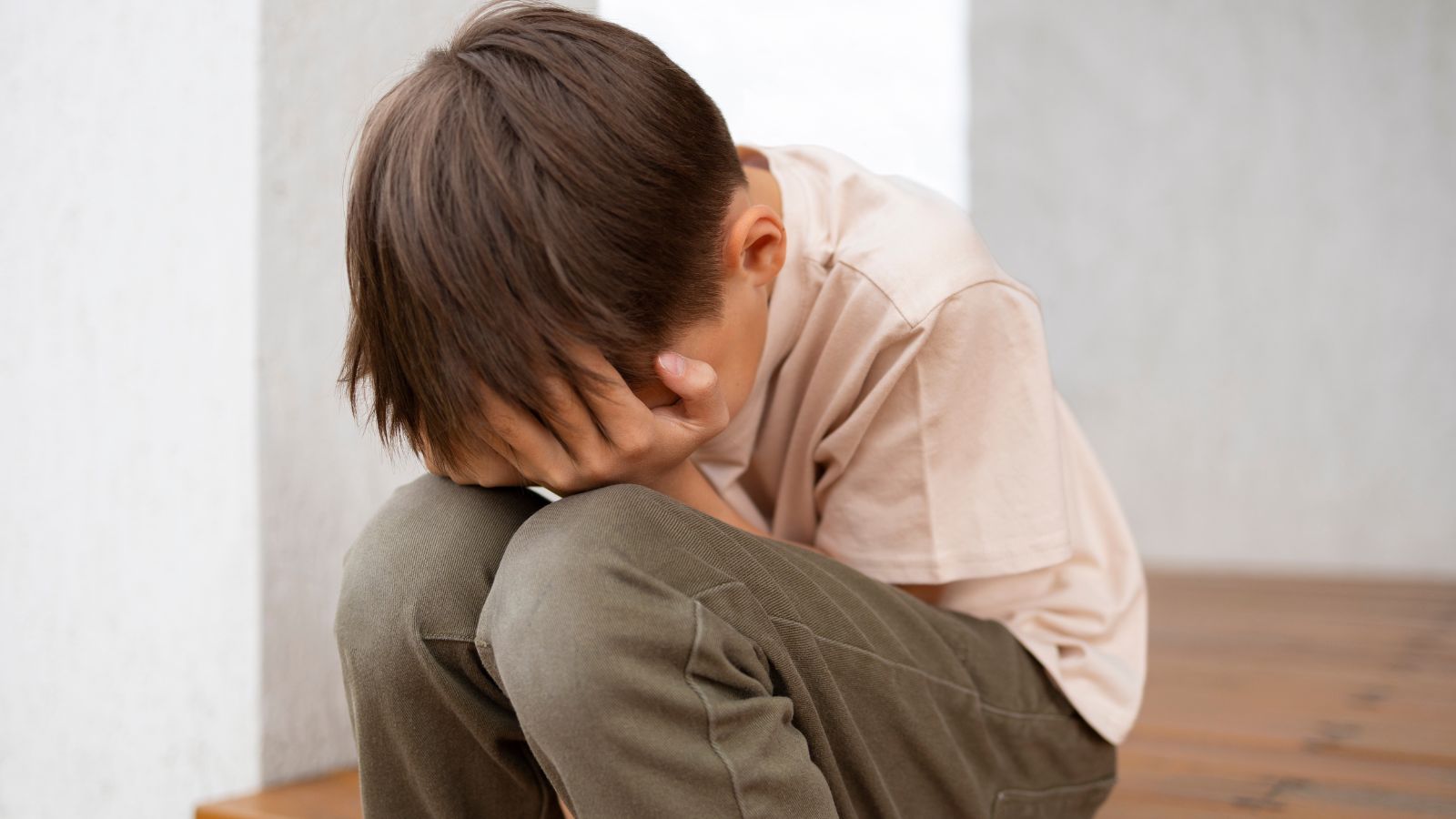 Boy crying and covering his face