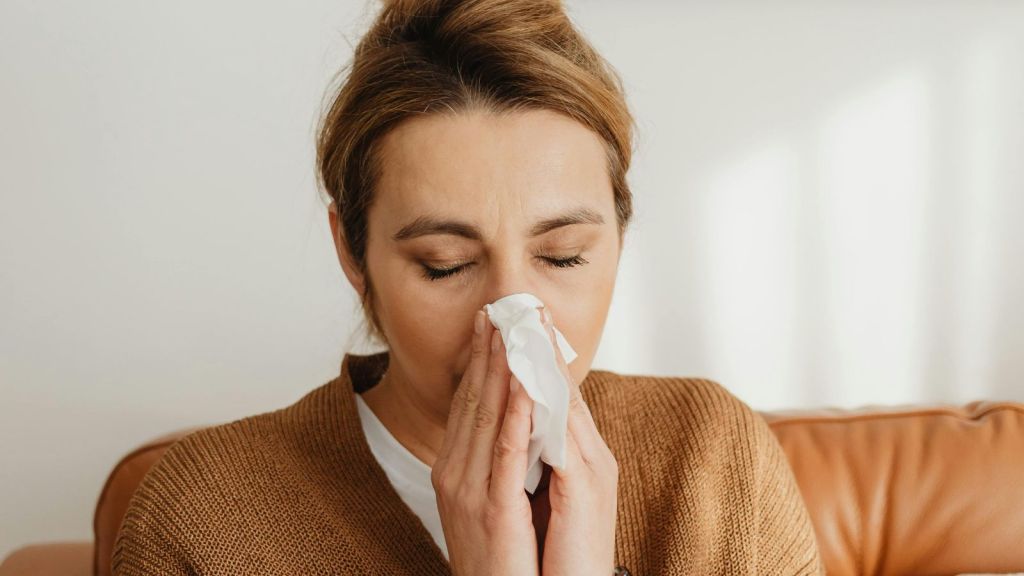 Woman blowing her nose on a tissue