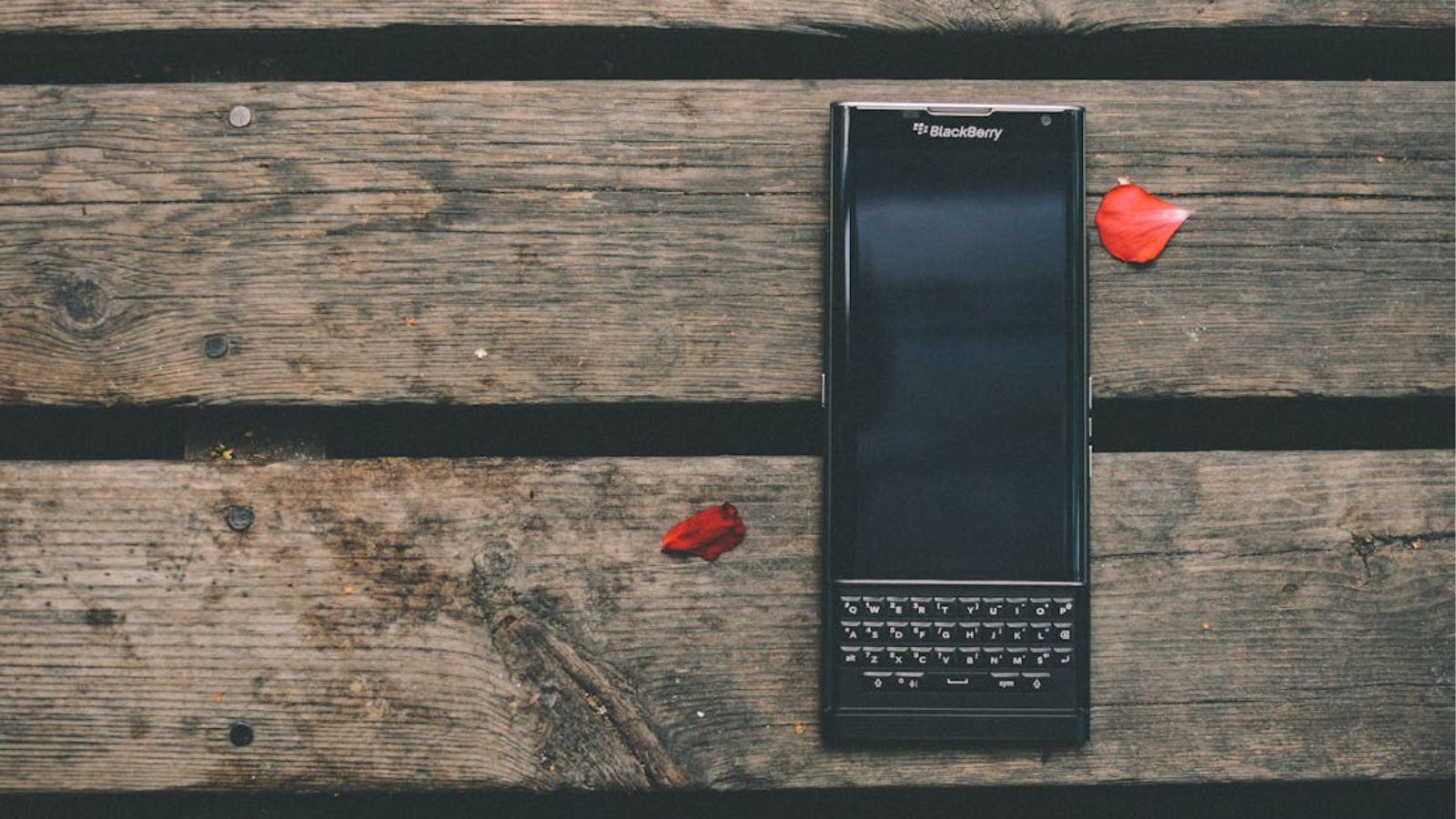 A modern Balcberry phone sitting on a rustic wooden table