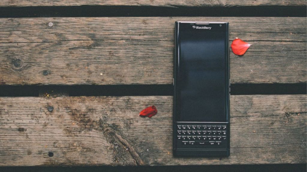 A modern Balcberry phone sitting on a rustic wooden table
