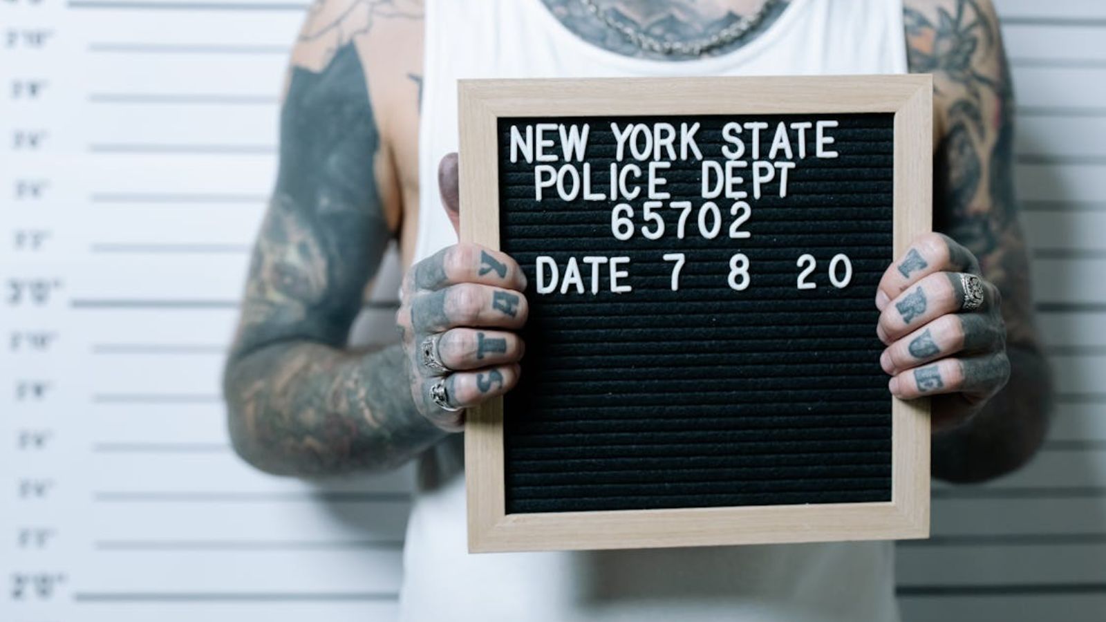 Mugshot of a man with tattoos all over his body