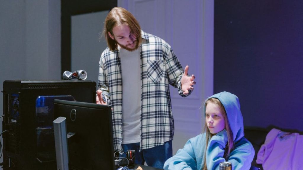 Man talking to a teenage girl while in front of computer