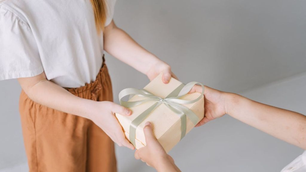 Woman handing a gift to another person