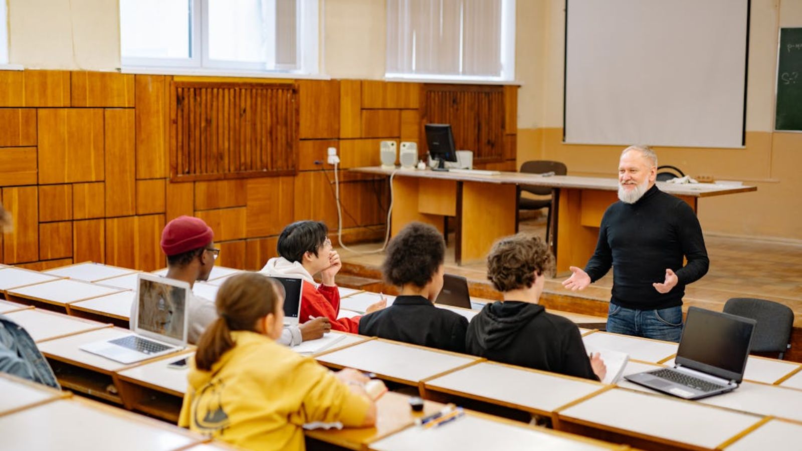 A Professor Insisted on Starting His Class on Time, so He Entered the Classroom Despite Another Professor Still Doing a Presentation College class with a professor discussing the lesson in front