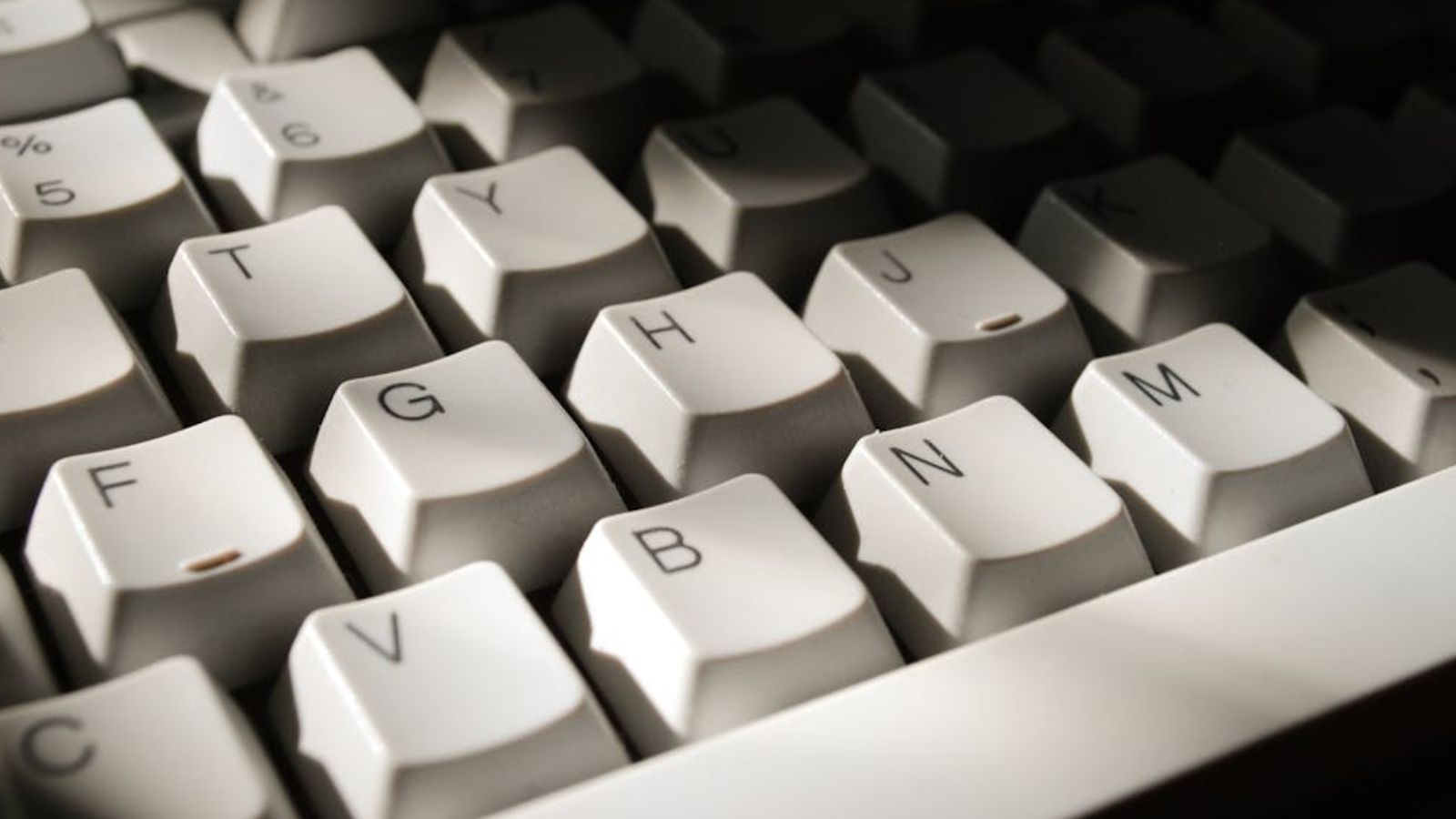 A white keyboard wth a shadow covering the top right portion