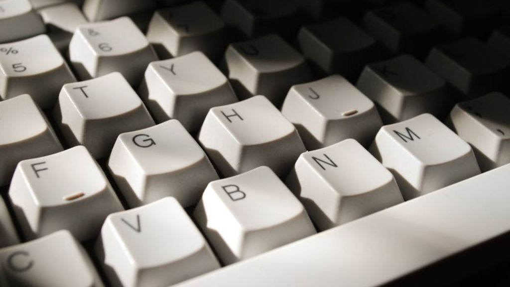 A white keyboard wth a shadow covering the top right portion