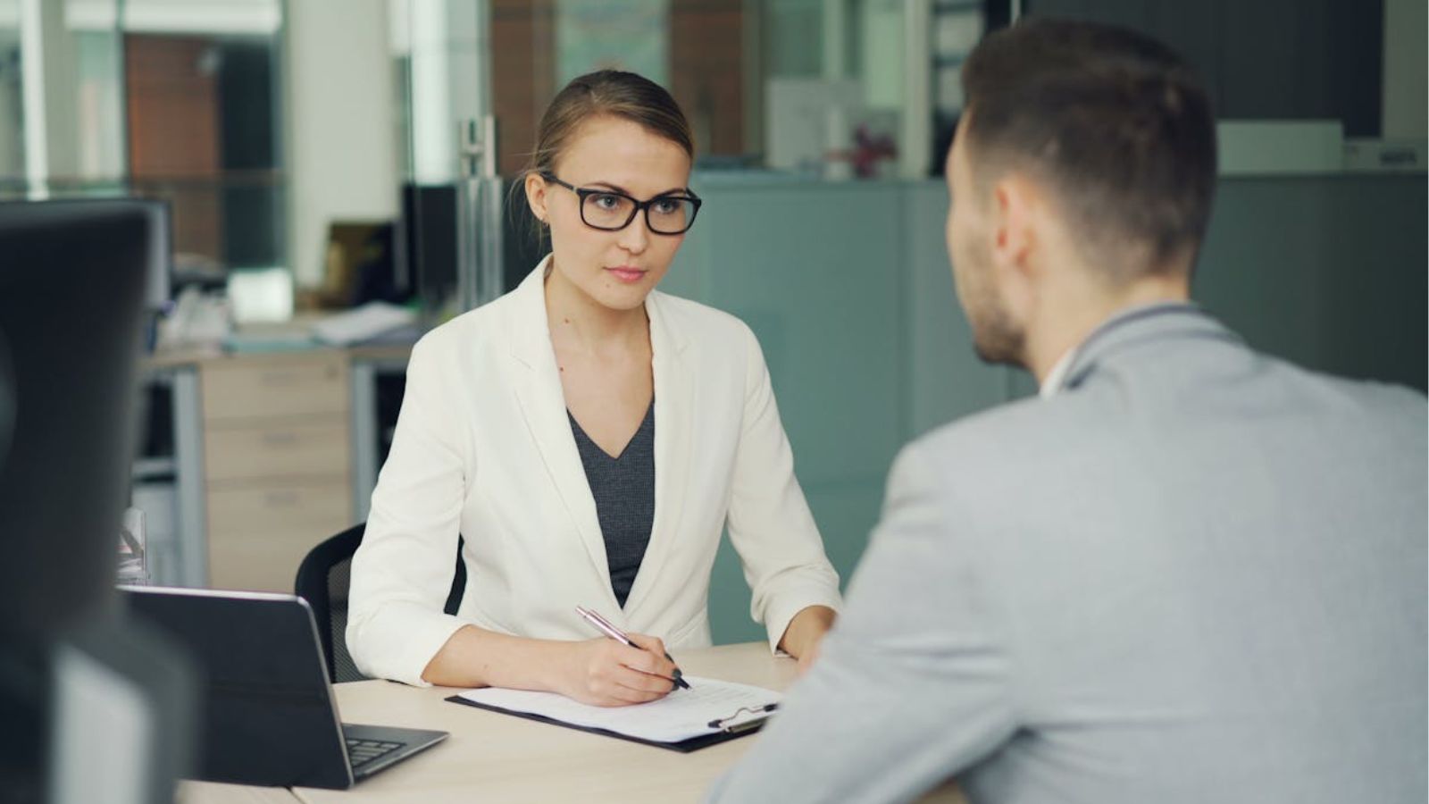 Man Worked In A Remote IT Team That Forgot A New Hire Completely, And He Discovered Something That Shocked Him And His Colleagues Two professionals in a serious business meeting at a modern office setting