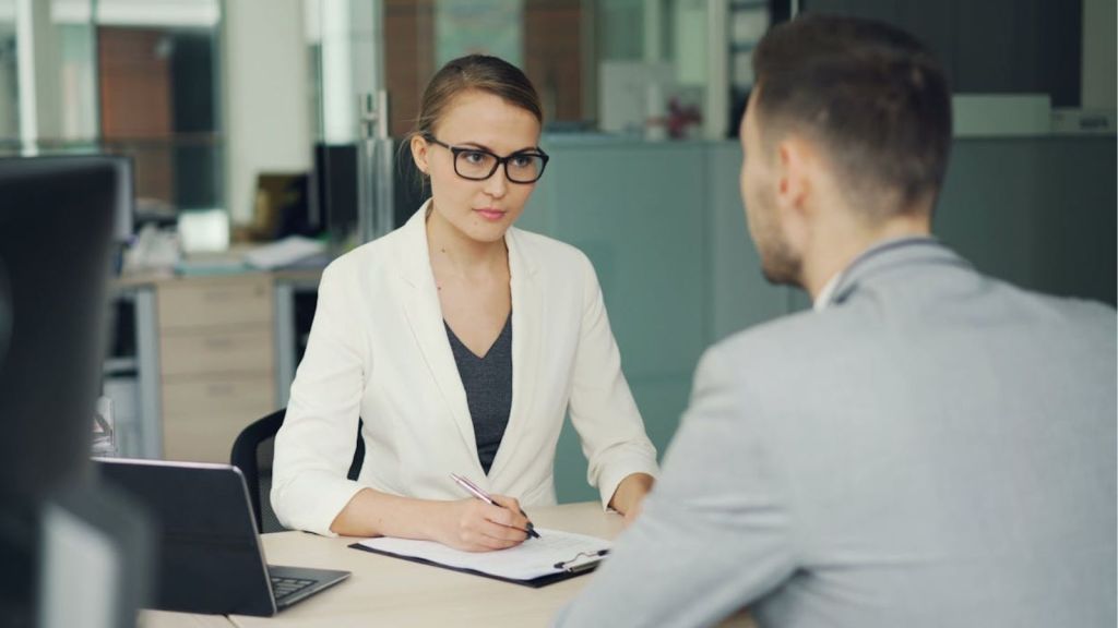 Two professionals in a serious business meeting at a modern office setting