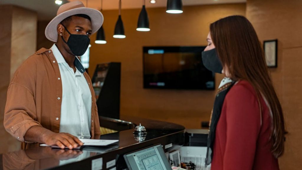 Man talking to the female front desk officer in a hotel