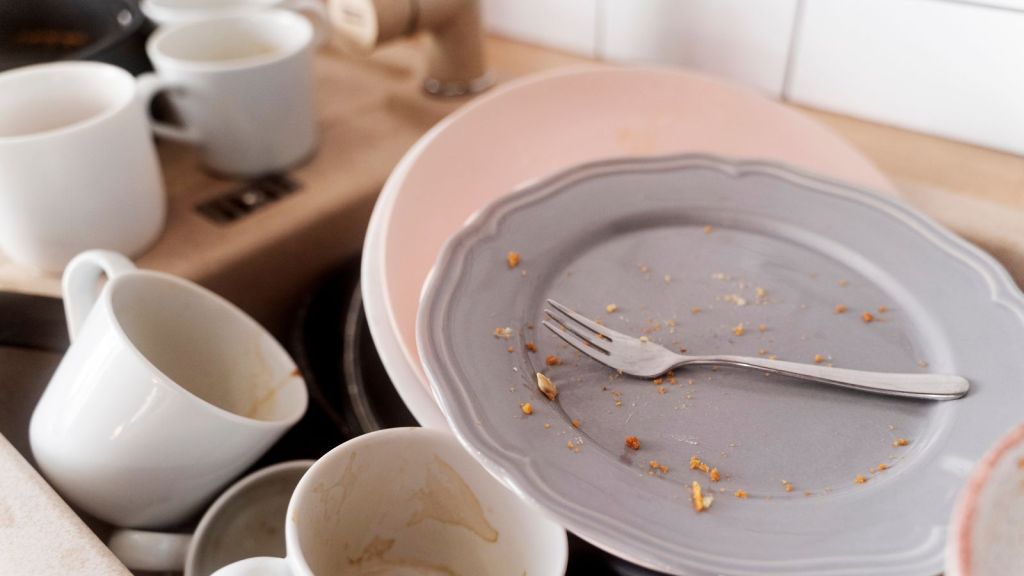 A pile of dirty dishes on the sink