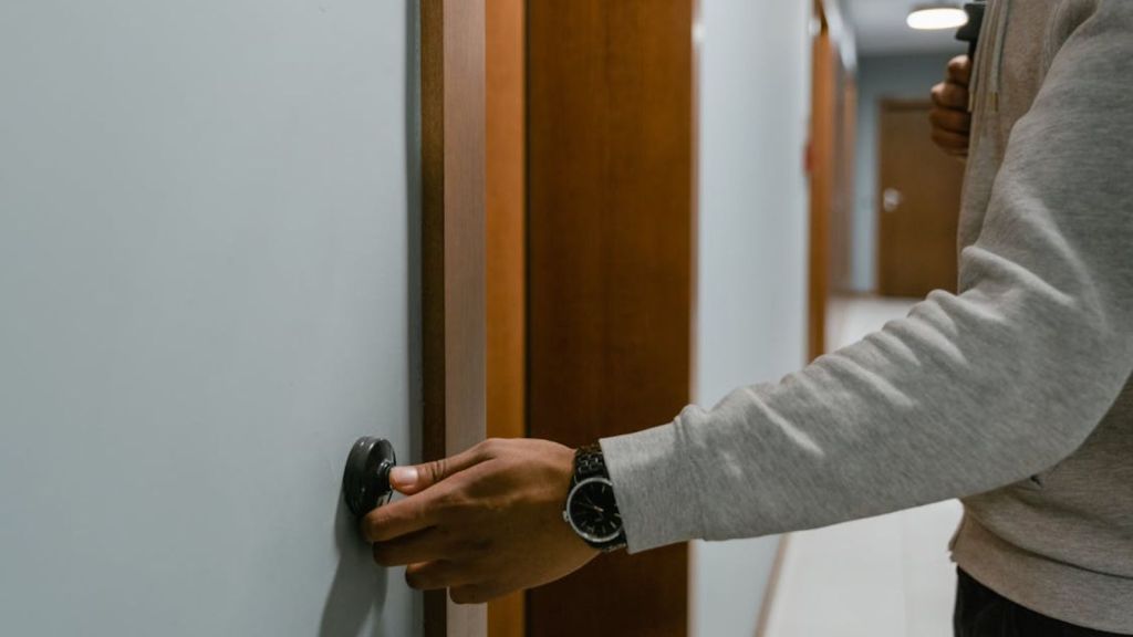 Person ringing the doorbell on an apartment unit