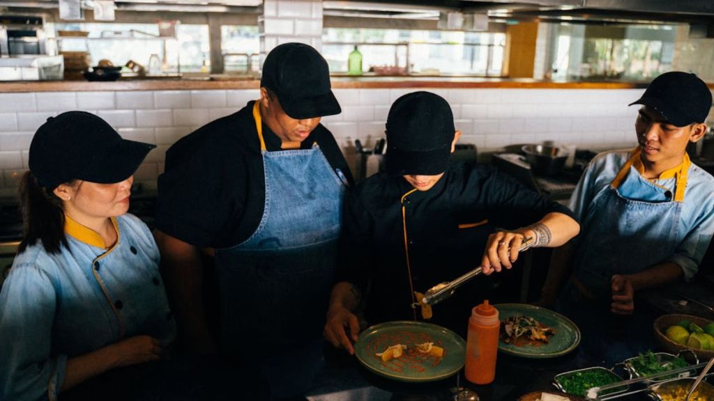 Chefs in a professional kitchen preparing and plating gourmet dishes with precision and teamwork