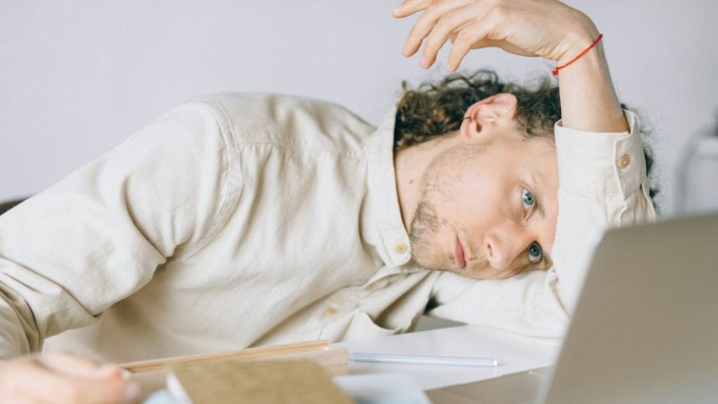Tired employee laying his head on the desk