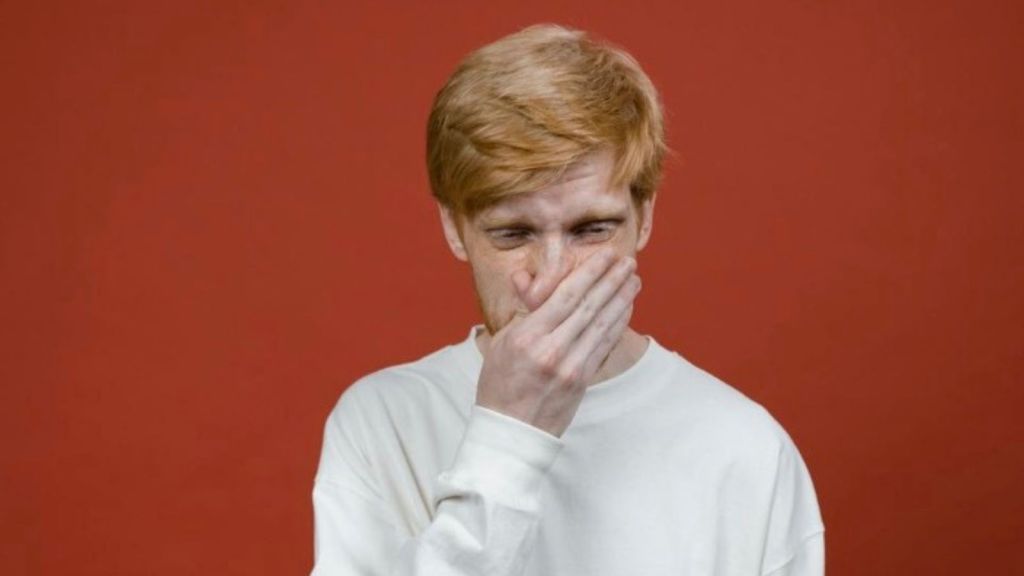 man covering his nose