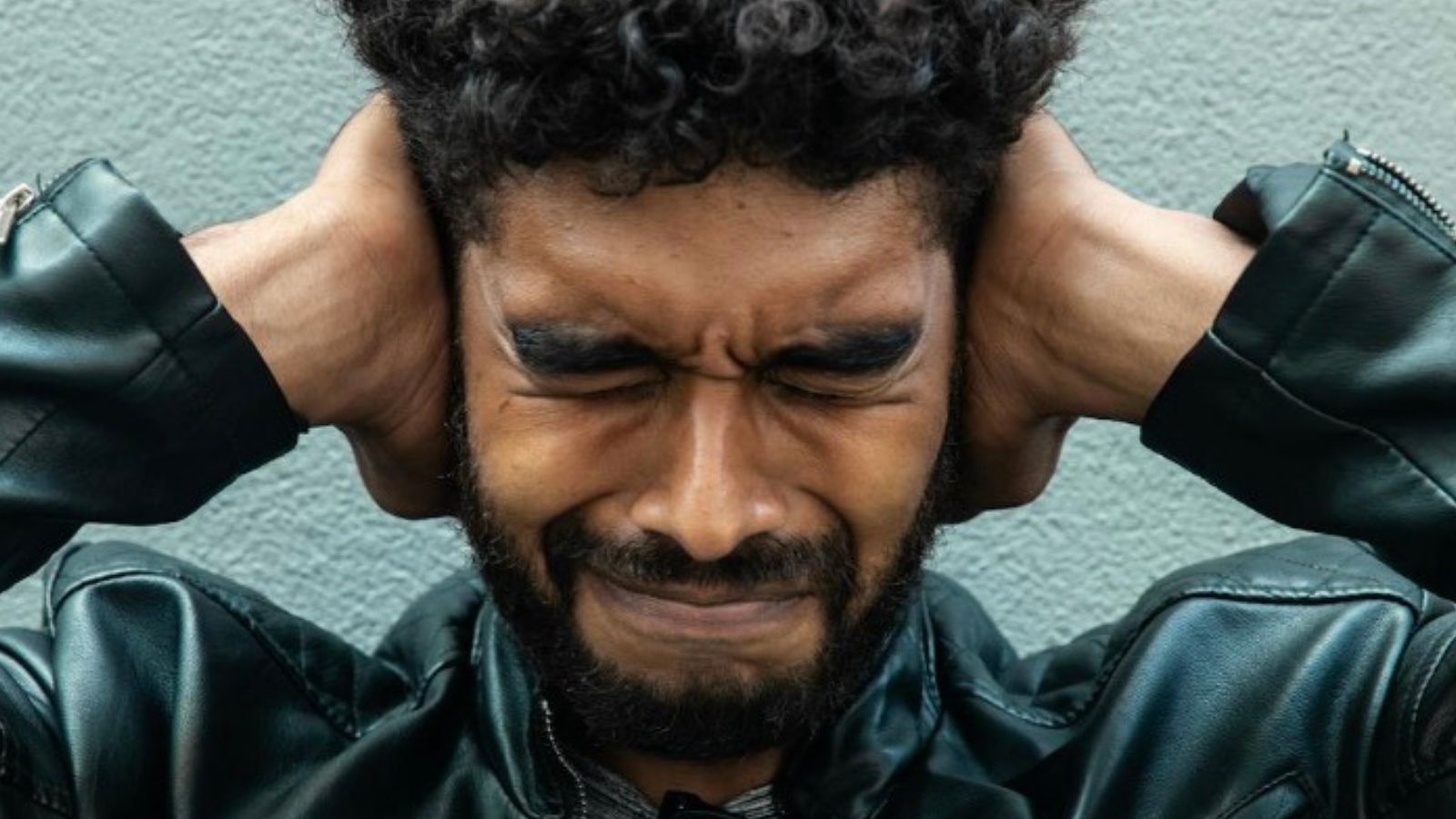 Man Is Annoyed at His Loud College Student Neighbors Throwing Parties, so He Blasts Death Metal While They Try to Study for Finals man covering his ears to block out noise