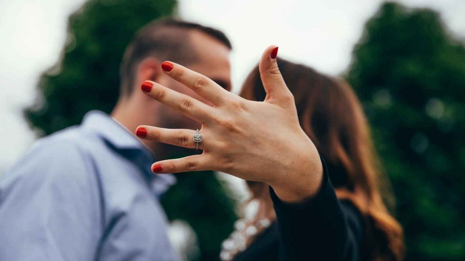 engaged couple showing off engagement ring