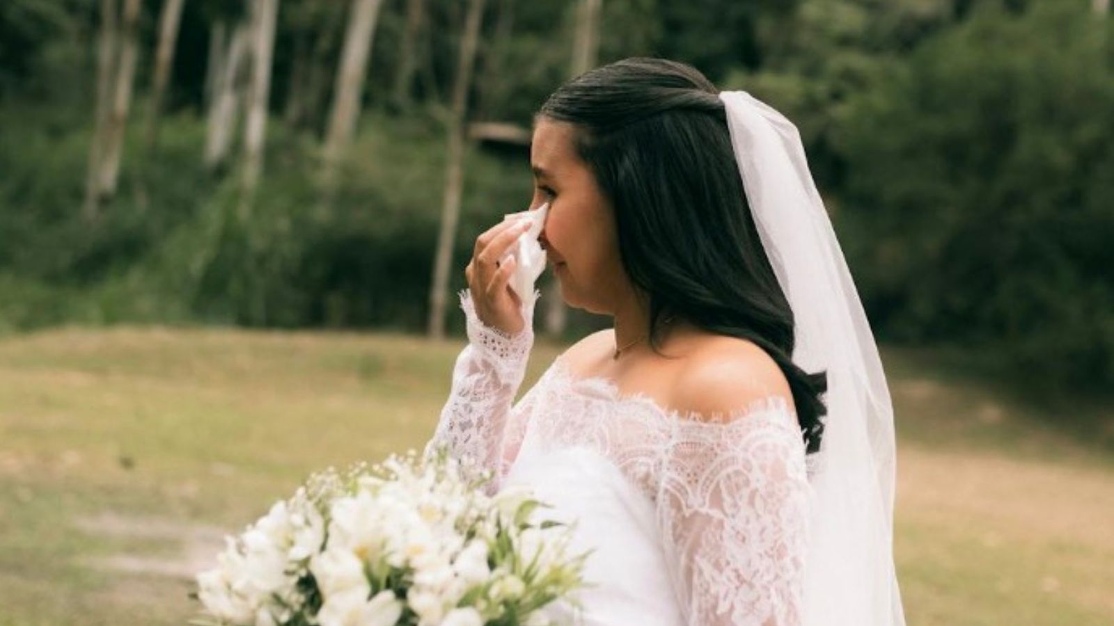 sad bride wiping her eyes with a tissue