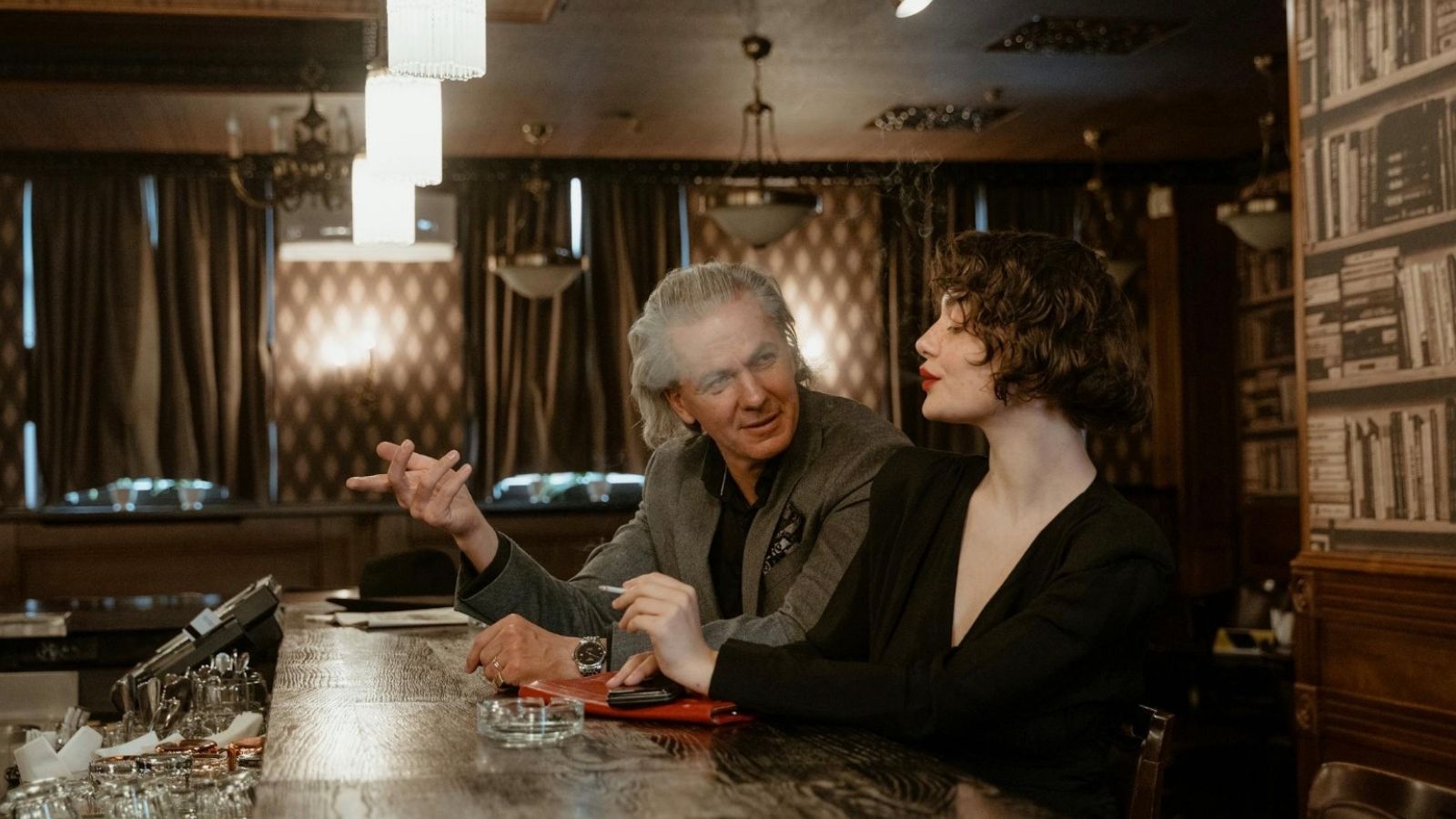 He Was Mourning His Late Mother, Then Learned His Dad Already Moved On With a Much Younger Woman older man and younger woman at a bar
