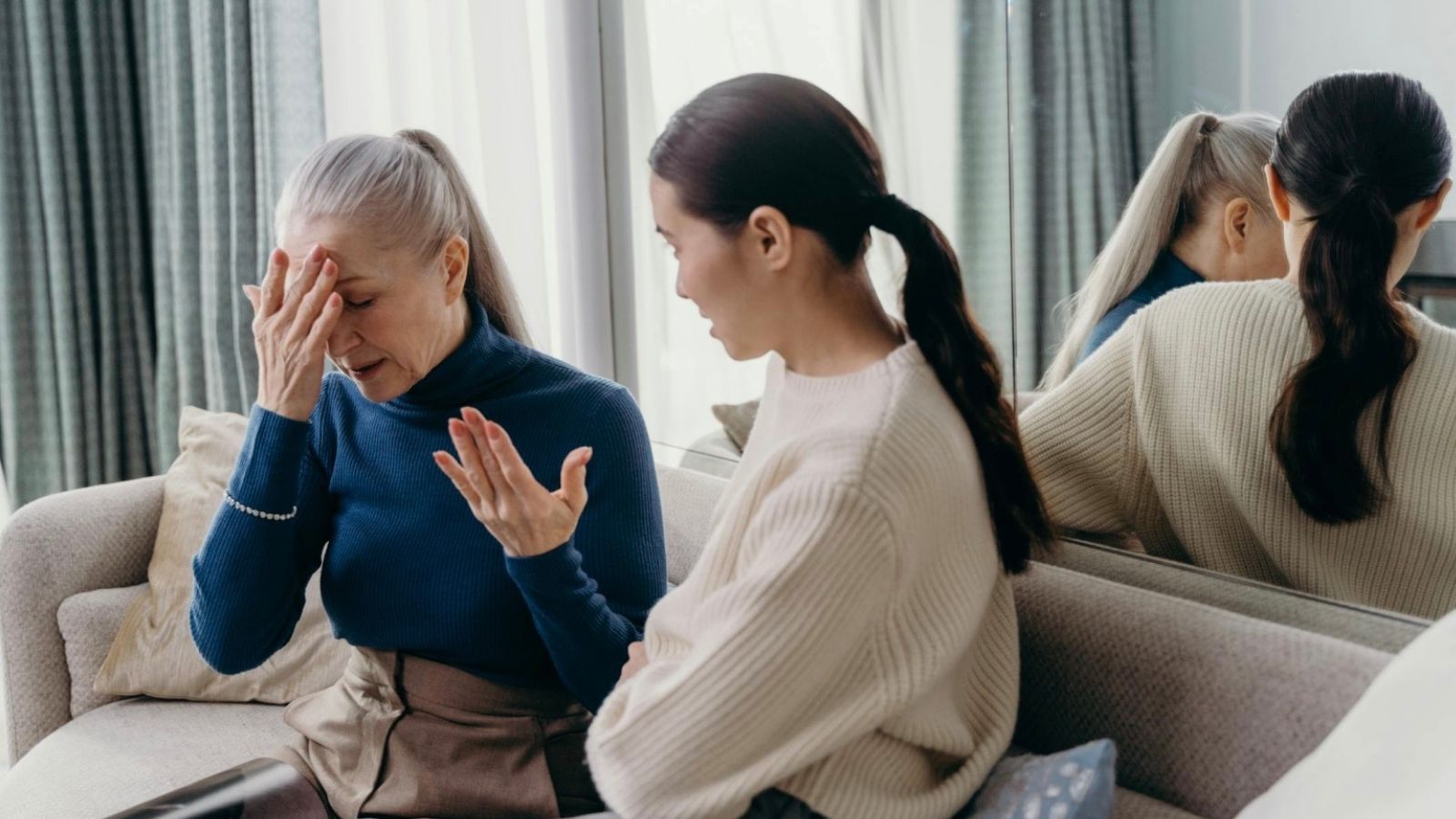 woman and her mother sitting on couch talking