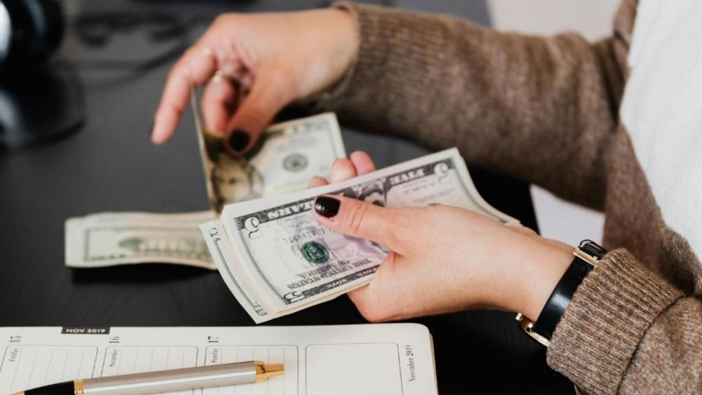 woman counting dollar bills