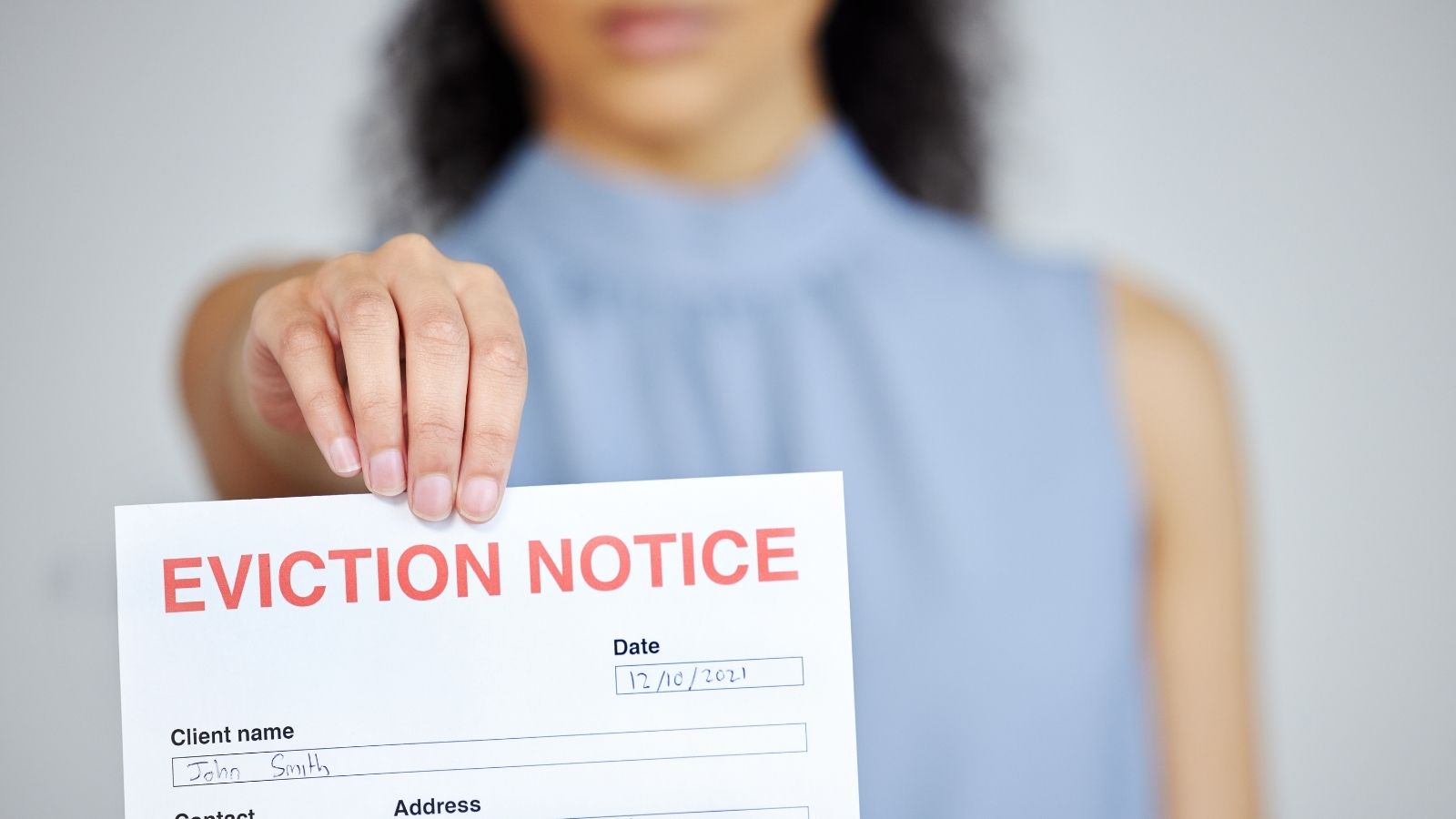 Months of Unpaid Rent Led to an Unexpected Offer From a Landlord woman holding out a paper that reads "eviction notice"