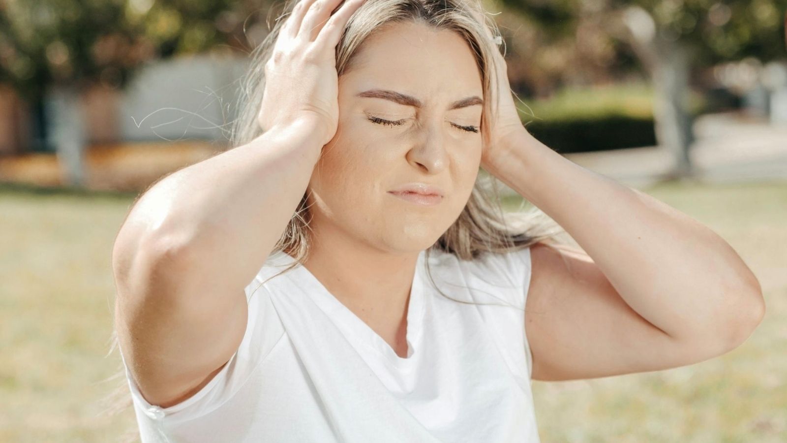 woman covering ears because of noise