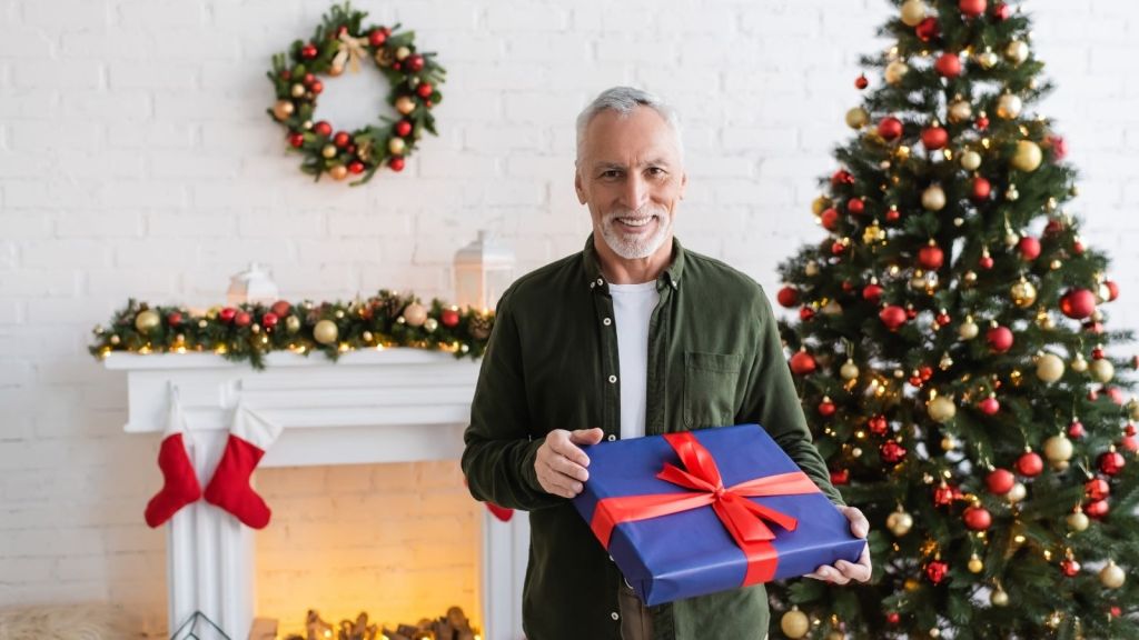 older man holding a Christmas present