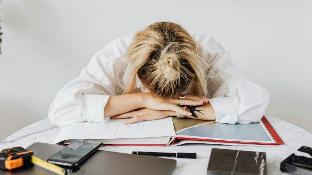 stressed out woman with her head on her desk