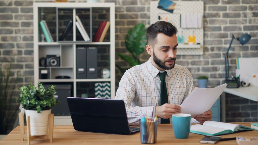 Man in office holding a file