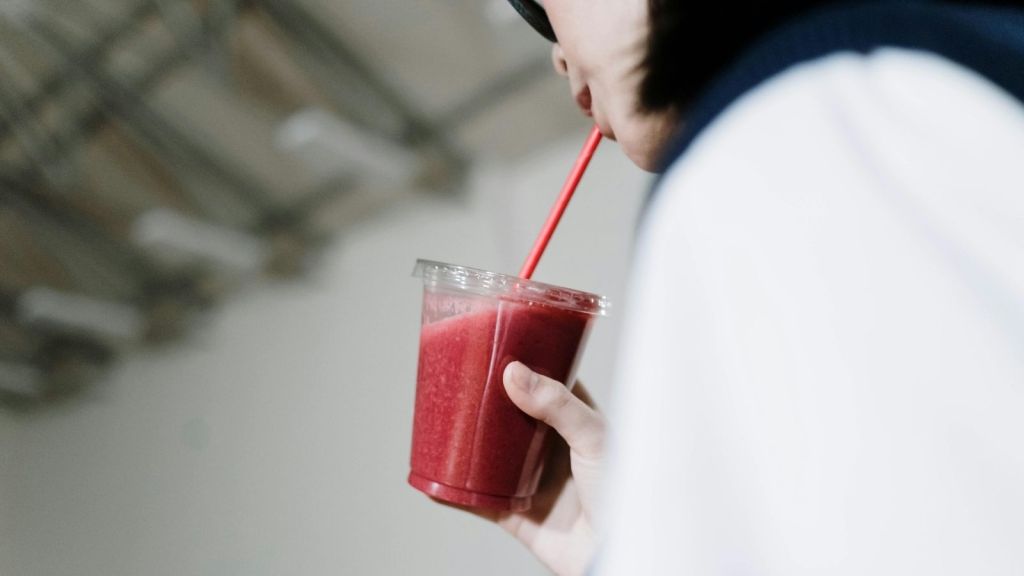 Woman drinking smoothie from to-go cup