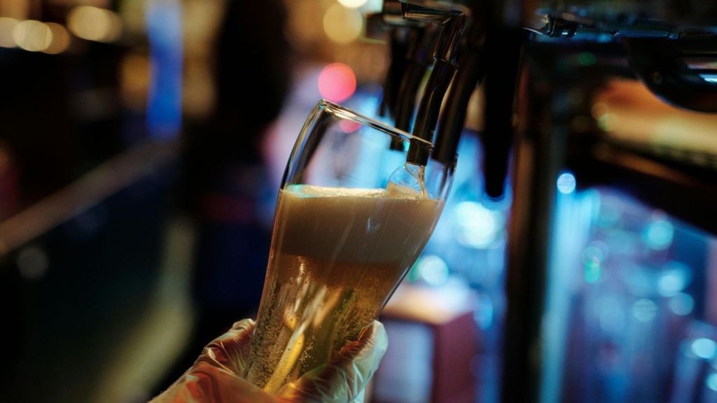 Beer being poured from tap into pint glass