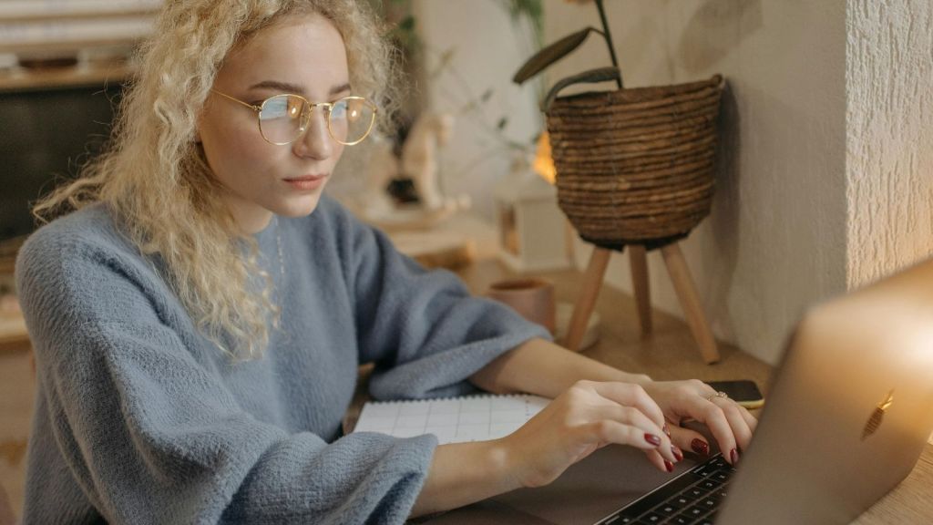 Woman typing at a laptop at home