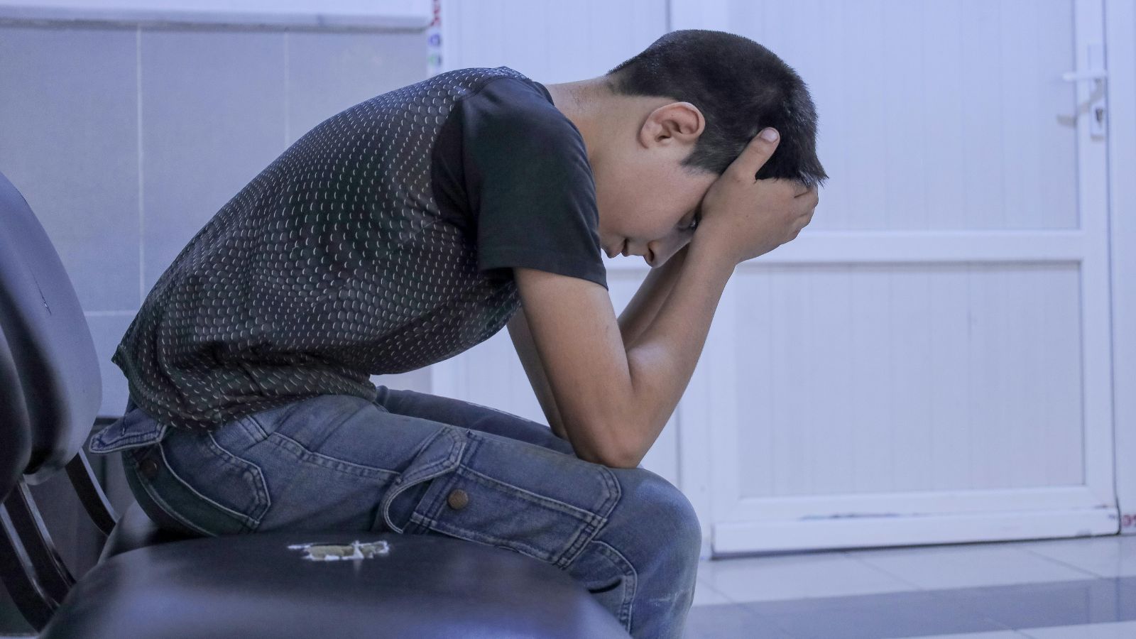 sad kid sitting on a chair
