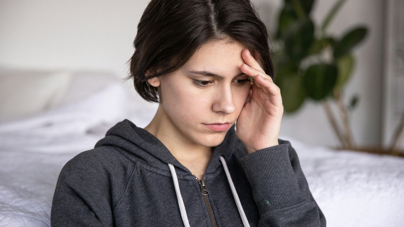 The Postpartum Standoff: How One Man’s Integrity Saved a Friendship and Protected a New Mom Woman in grey hoodie holding her head