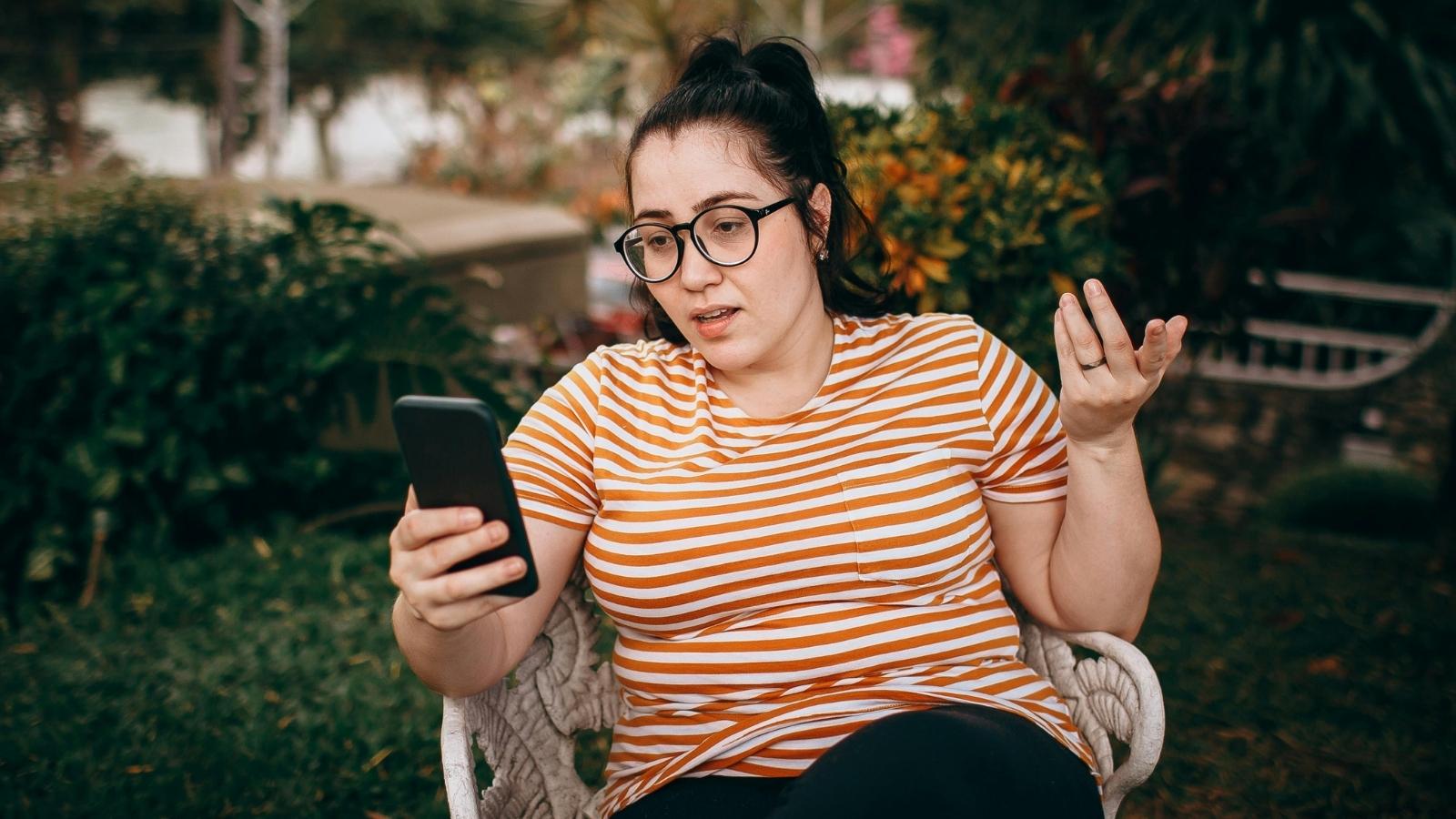 annoyed woman in red striped shirt texting