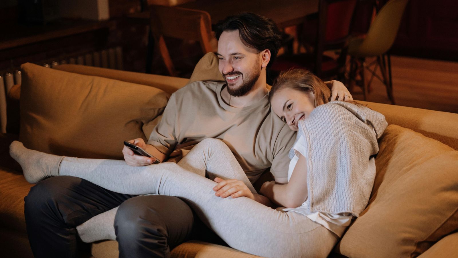 Man and woman sitting on the couch laughing