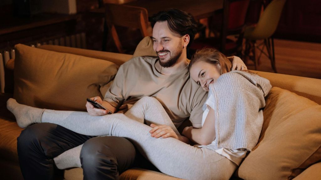 Man and woman sitting on the couch laughing