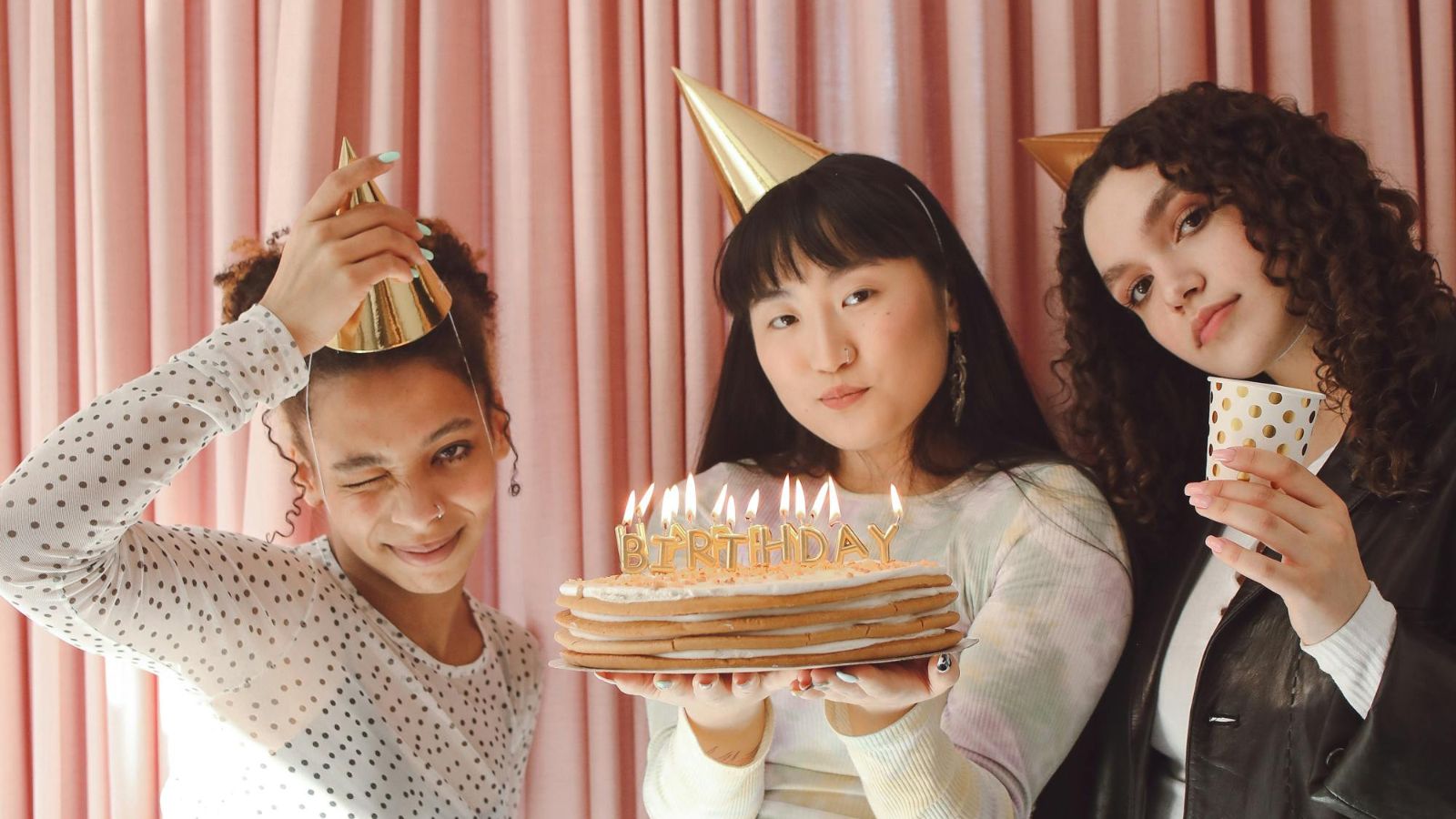 Roommate’s Mom Insists on Cooking Birthday Dinner, but Woman Has Different Plans for Her Day Young women holding a cake, celebrating a birthday